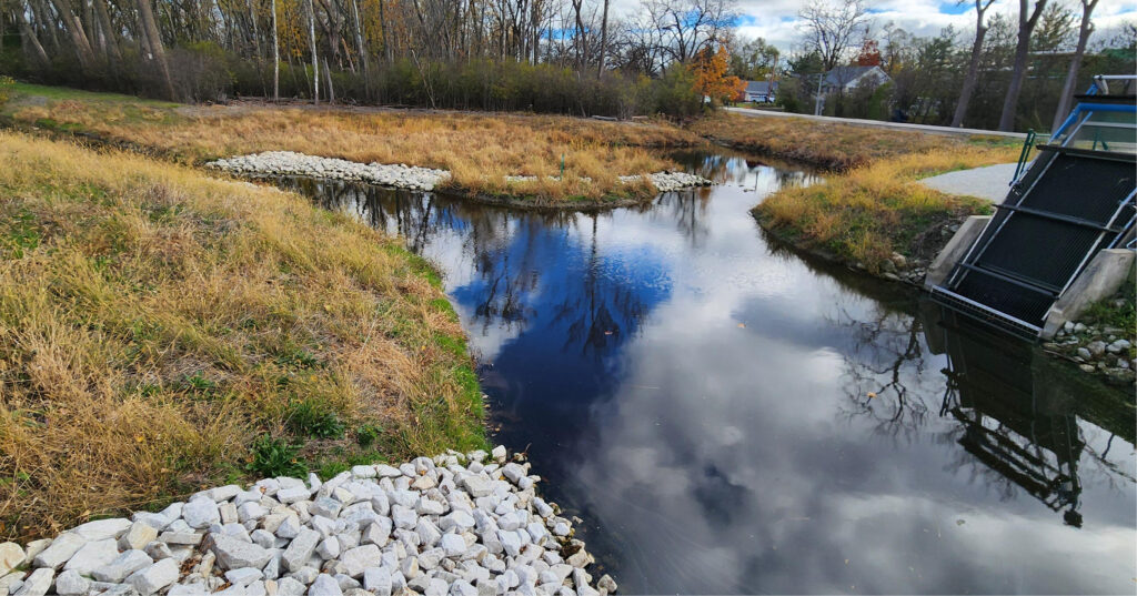 Zone naturelle aménagée pour la gestion de l'eau, intégrant un bassin de rétention et des solutions basées sur la nature pour réguler les eaux pluviales et préserver l'environnement.